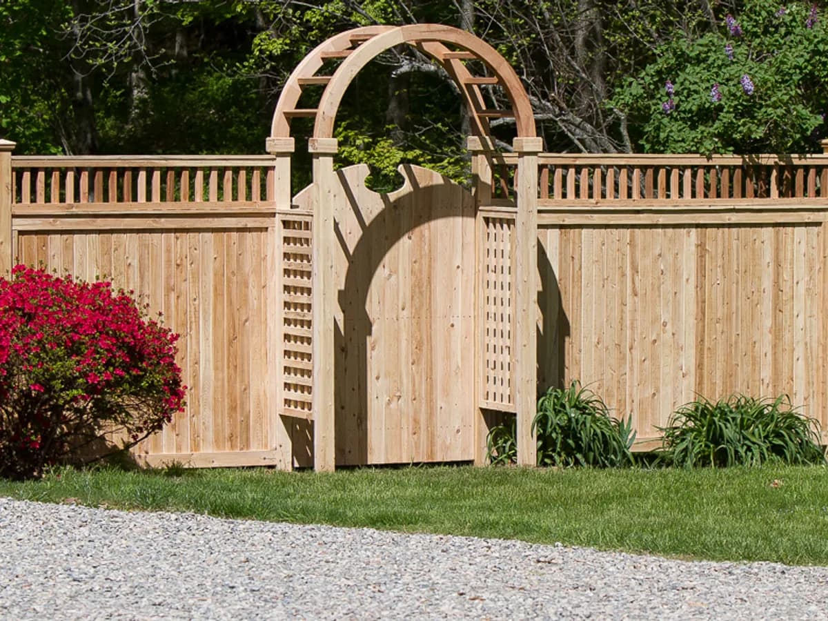 Hand-built cedar privacy fence with arched entry and lattice top at a Connecticut residence