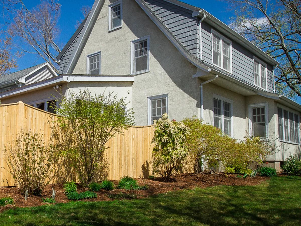 Cedar scalloped privacy fence in front of a Connecticut colonial home